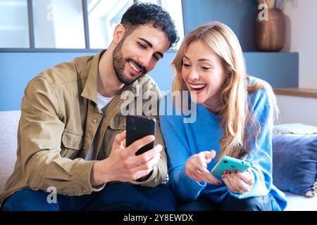 Happy man and woman have fun browsing the internet on a smartphone. Stock Photo