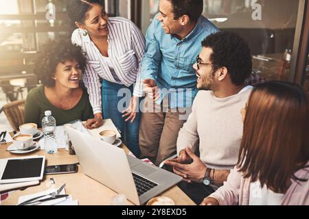 Business people, laughing and laptop for meeting at coffee shop with startup project development or company website launch. Remote work, team lunch Stock Photo