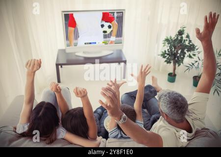 Family cheering and watching the world cup at home in the living room Stock Photo