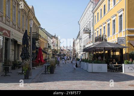 Kaunas, Lithuania - Sep 8, 2024: People walking in Kaunas. Streets, buildings. Lifestyle in the urban area. Sunny summer day. Selective focus Stock Photo