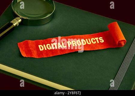 The concept of the info business. The text of DIGITAL PRODUCTS is written on a piece of unfolded red note, paper on a green book. Saturated colors Stock Photo