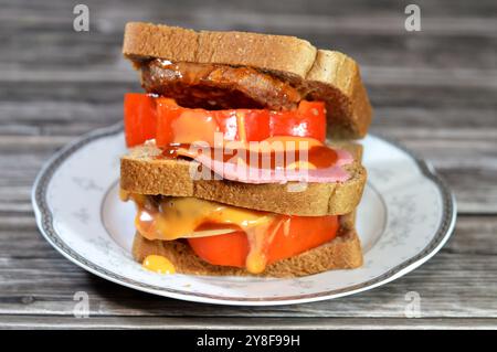 multilayer whole wheat brown toast filled with fried beef burger cooked in a boiling shallow oil with slices of colored bell peppers and Lunch meats, Stock Photo