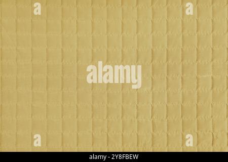 Checkered stitching pattern, yellow quilted fabric background. Blanket or puffer jacket, stitch square texture close up, macro. Wallpaper, backdrop. Stock Photo