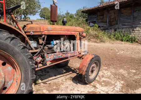 Old weathered grunge vintage tractor on a rural village farm closeup on sunny summer day Stock Photo