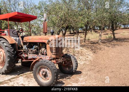 Old weathered grunge vintage tractor on a rural village farm closeup on sunny summer day Stock Photo