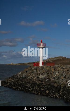 A red and white lightthouse stands beautifully on the seashore. A beautiful view. Stock Photo