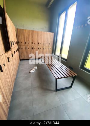 Wooden bench in empty locker room at gym Stock Photo