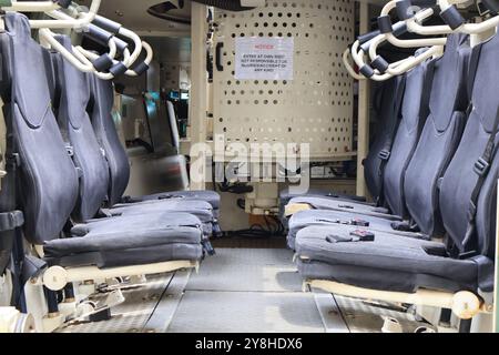 Inside view of a military vehicle showcasing secure, empty seats and rugged design. Stock Photo