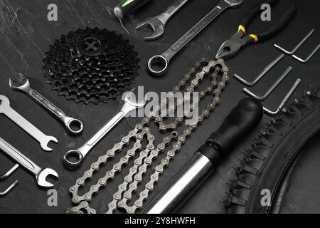 Parts of bicycle and tools on black table Stock Photo