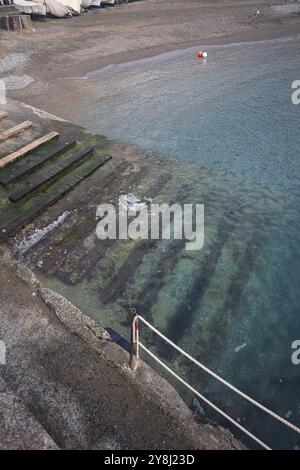 Towage lane in a pier next to a beach in an italian town on a cloudy day Stock Photo