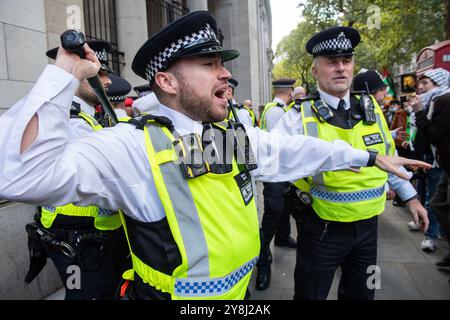 London, England, UK. 5th Oct, 2024. A police officer raises a baton to prevent scuffles with protesters during the National March for Palestine in London. The march called for an end to Israeli military action in Gaza and Lebanon, as tensions escalated between demonstrators and law enforcement. Several arrests were made during the event, which highlighted the urgent demands for justice and peace in the Middle East. (Credit Image: © Thomas Krych/ZUMA Press Wire) EDITORIAL USAGE ONLY! Not for Commercial USAGE! Stock Photo