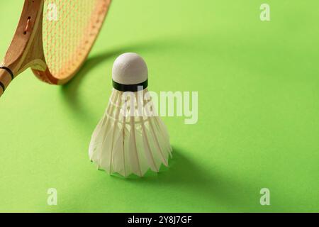 Wooden badminton rackets and white feather badminton shuttlecocks on green background. Close up. Copy space. Stock Photo