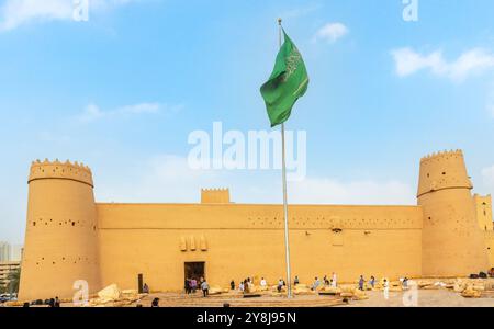 Masmak Fortress towers and walls with green Saudi Arabian national flag waving on the wind, Qasr al-Hukm district, Al Riyadh, Saudi Arabia Stock Photo