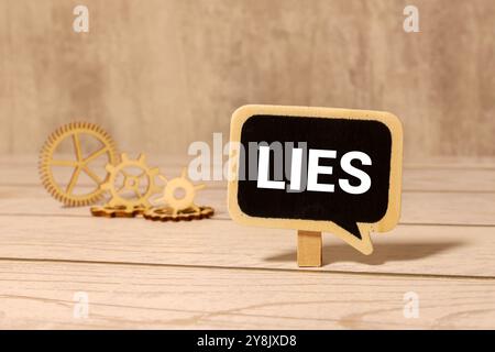 Words "lies, lies, lies" in cut out magazine letters on wooden background Stock Photo