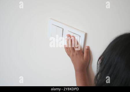 child finger turning on lighting switch with copyspace  Stock Photo