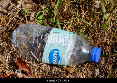 Empty plastic water bottle laying on the ground Stock Photo