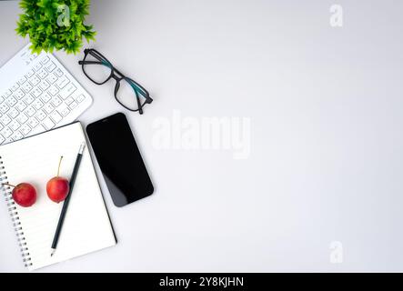 Top view of mock up modern workspace with blank screen smartphone, keyboard. Office situation with keyboard and accessories isolated on white. Copy sp Stock Photo