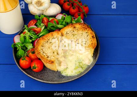 Creamy butter pastry garlic chicken Kiev pie meal with fresh salad Stock Photo