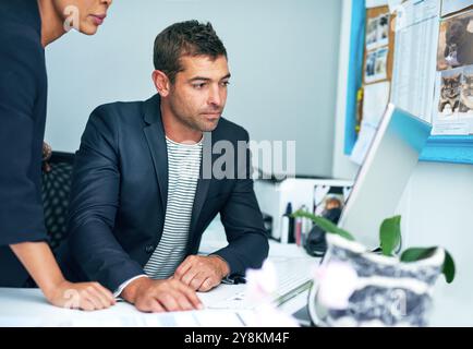 Business, people and reading on computer at office for digital files or data as administrators. Employees, helping and serious with coworking as compa Stock Photo