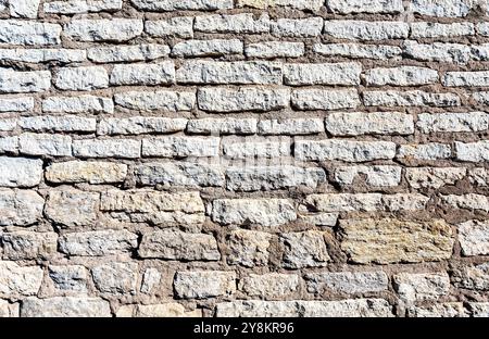Ancient weathered rough stone wall as creative background. Grunge brick wall texture background Stock Photo