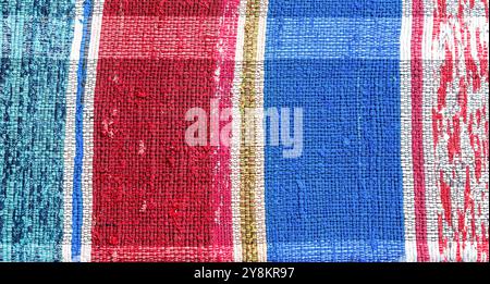 Old homespun doormat made from strips of cloth as background. Handmade texture of a rug from different fabrics Stock Photo