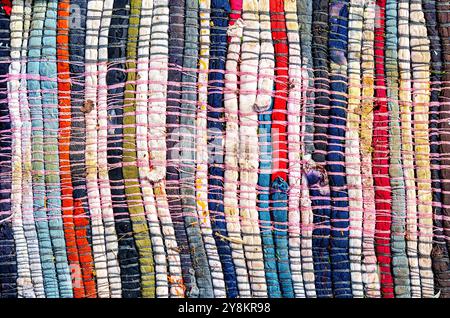Old homespun doormat made from strips of cloth as background. Handmade texture of a rug from different fabrics Stock Photo