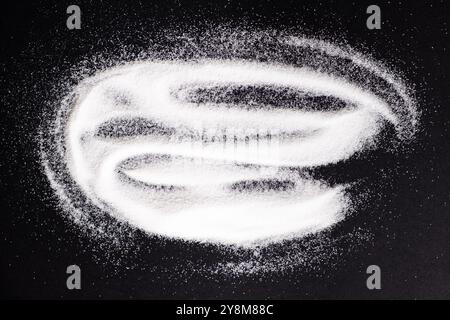 Finely ground stone white rock salt texture on black background, top view Stock Photo