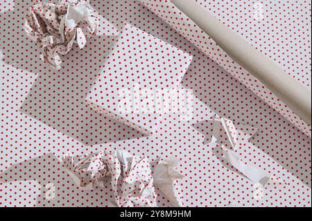 Close-up of a wrapped gift and crumpled paper with red polka dots. Stock Photo