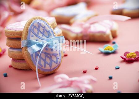 Easter baking background of frosted cookies in shape of egg on pink background Stock Photo