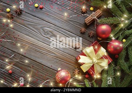Flat lay top view at Christmas bauble background with red gift box, glass balls, light garland and fir twigs Stock Photo