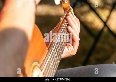 hand of a man playing the Spanish guitar or classical guitar at an outdoor event, musical concept Stock Photo