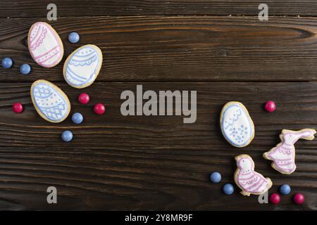 Candies, Easter frosted cookies in shape of egg chicken and rabbit on wooden table background. Flat lay mockup with copy space Stock Photo