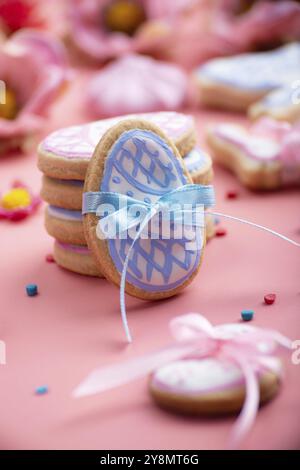 Easter baking background of frosted cookies in shape of egg on pink background Stock Photo
