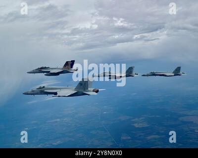 Four U.S. Navy F/A-18E/F Super Hornets conduct a formation flyover to honor the 100th birthday of former U.S. President James Earl 'Jimmy' Carter in P Stock Photo