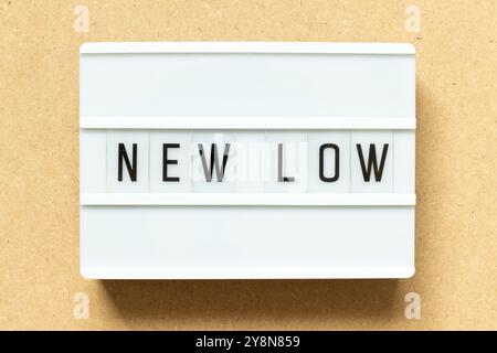 Lightbox with word new low on wood background Stock Photo