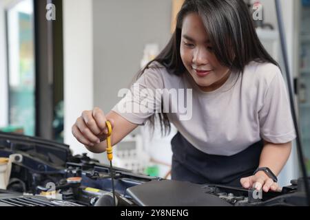 A young female checking a car Stock Photo