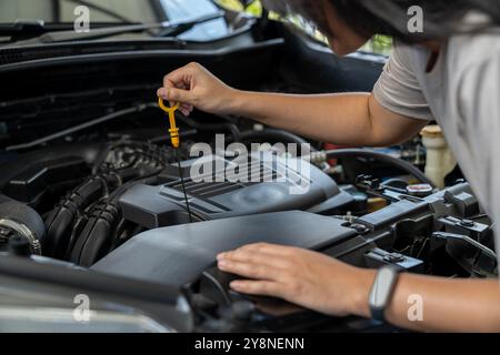 A young female checking a car Stock Photo