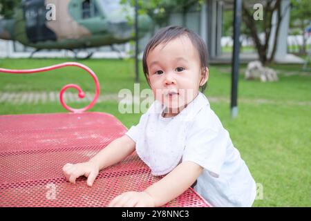 Cheerful asian toddler boy having fun on the grass at playground Stock Photo
