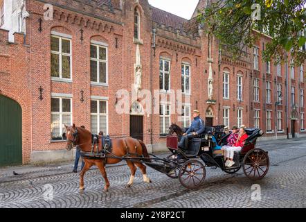 Belgium, Flanders, Bruges, Wijngaardplein, tourists enjoying sightseeing carriage ride Stock Photo