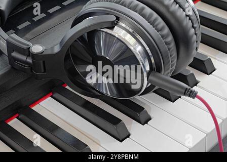 Full-sized headphones on a piano keyboard, close up shot. Abstract music background. Stock Photo