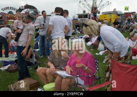 Queen Elizabeths Diamond Jubilee, a group women, one wearing a pretend crowd celebrate at the Epsom Derby horse racing festival. Group local friends On the Hill ( the non paying side of the race track) Epsom Downs, Surrey, England 2012 2010s UK HOMER SYKES Stock Photo