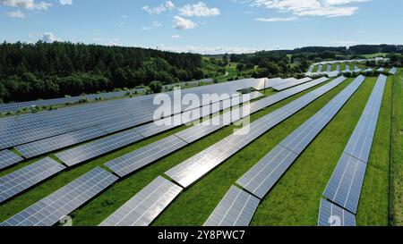 This stunning aerial view captures an expansive solar field, showcasing a vast array of solar panels harnessing the sun's energy. The orderly grid lay Stock Photo