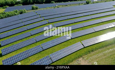 This stunning aerial view captures an expansive solar field, showcasing a vast array of solar panels harnessing the sun's energy. The orderly grid lay Stock Photo