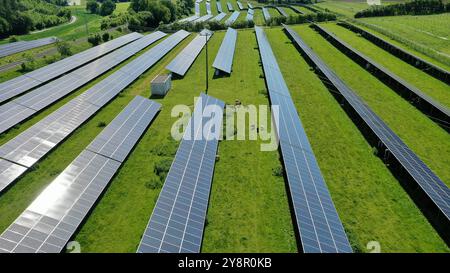 This stunning aerial view captures an expansive solar field, showcasing a vast array of solar panels harnessing the sun's energy. The orderly grid lay Stock Photo