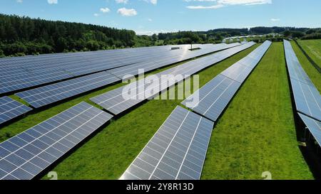 This stunning aerial view captures an expansive solar field, showcasing a vast array of solar panels harnessing the sun's energy. The orderly grid lay Stock Photo