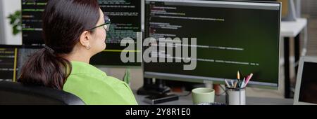 Website header shot of female senior IT spetialist program coding on multiple screens in software development office, copy space Stock Photo
