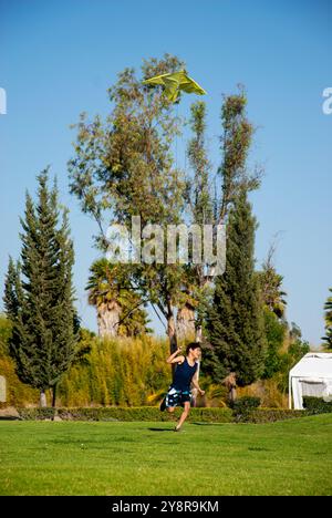 A boy running on a green field with a Stock Photo