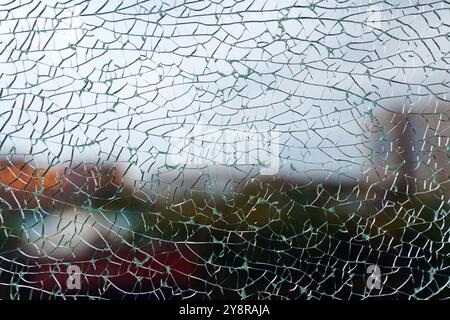 A close-up view of fragmented glass creating an abstract texture while hinting at a vibrant background in the urban environment Stock Photo