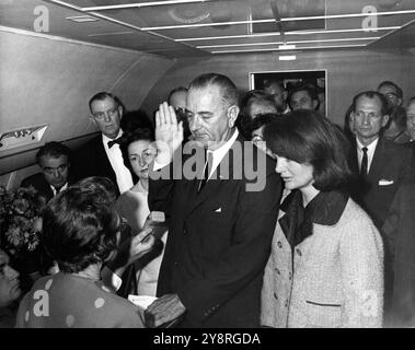 Lyndon B. Johnson taking the oath of office aboard Air Force One two hours and eight minutes after the assassination of John F. Kennedy, Dallas, Texas. Jackie Kennedy (right) Stock Photo