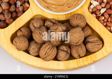 Peanuts, walnuts and hazelnuts in a wooden box with compartments. Three different types of nuts, shelled and shelled, decorative assortment and ready Stock Photo